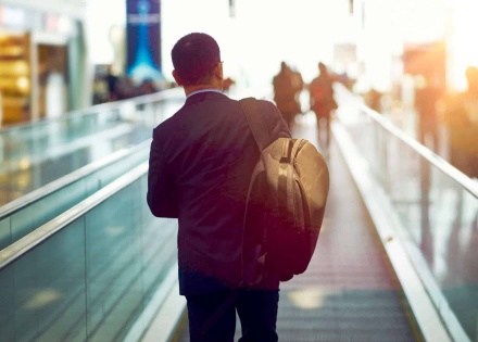 Man with briefcase on moving walkway in airport