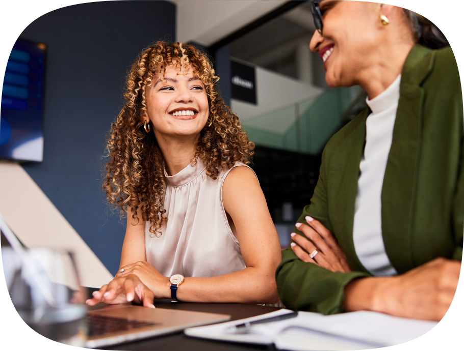 Two colleagues in an office setting sitting at a table discussing global hiring