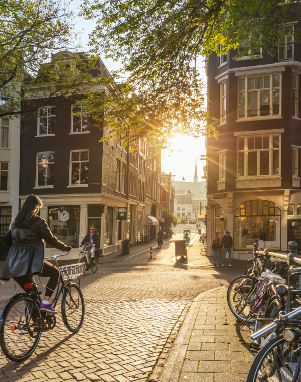 European city view with people walking and riding bicycles