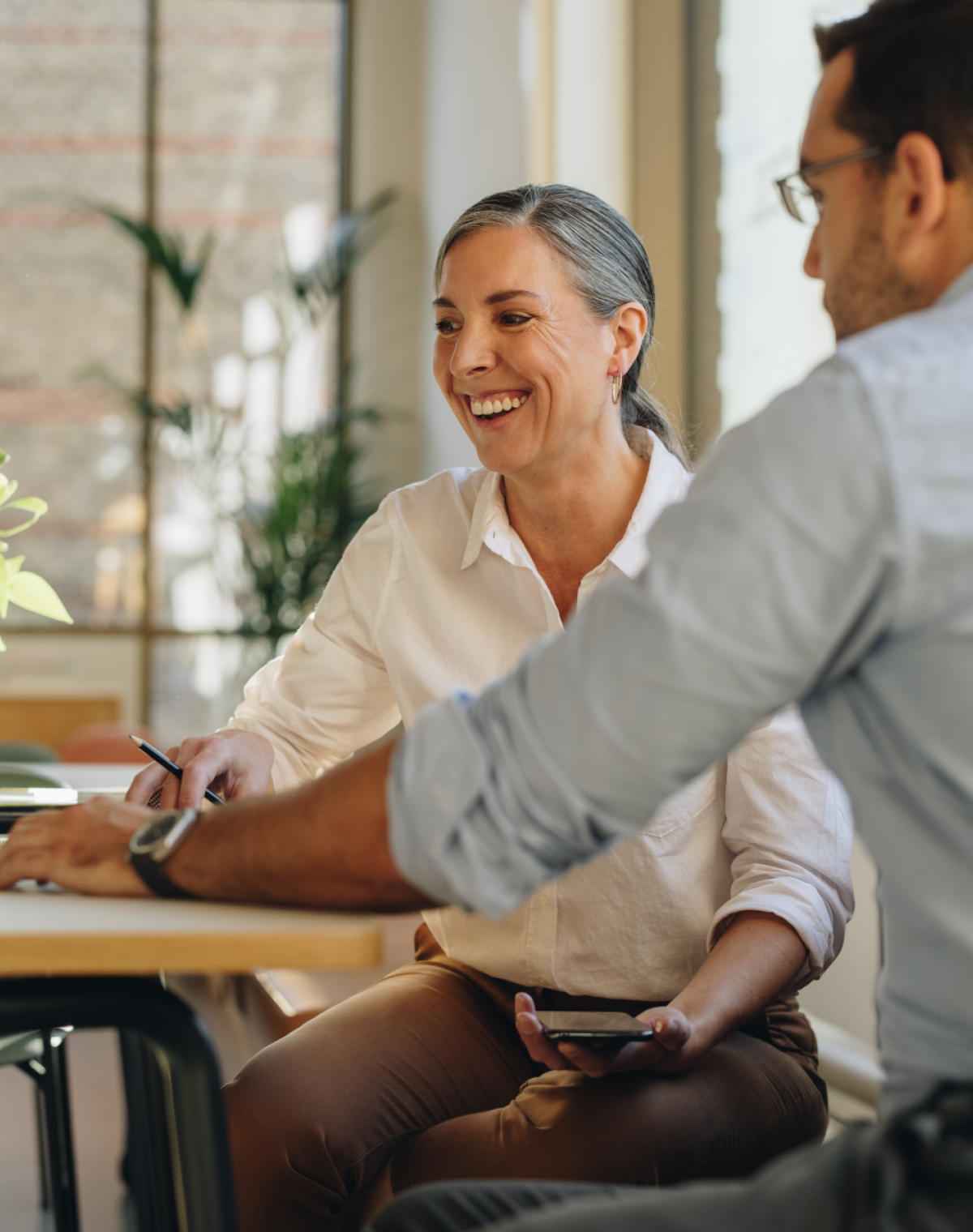 woman and man sitting at table looking at computer
