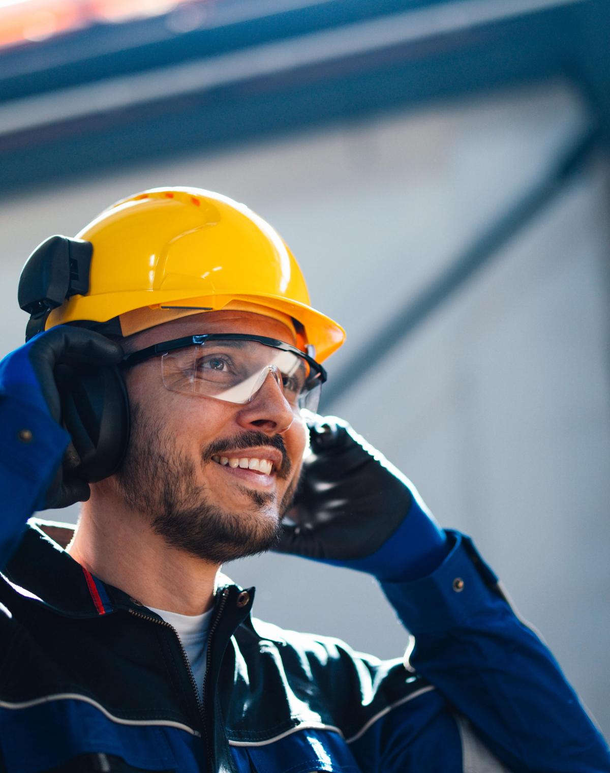 Man in construction zone with hard hat and safety glasses.