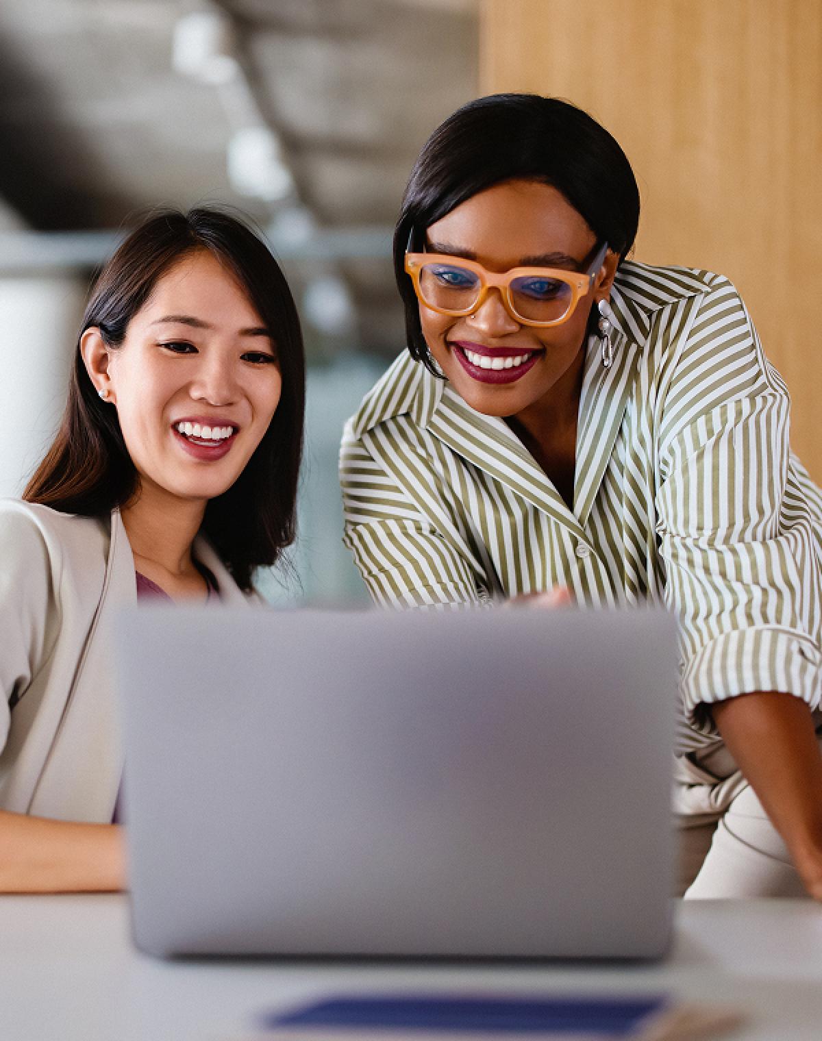 Two team members at an AI company reviewing work on a laptop, highlighting the power of hiring AI skills for innovation
