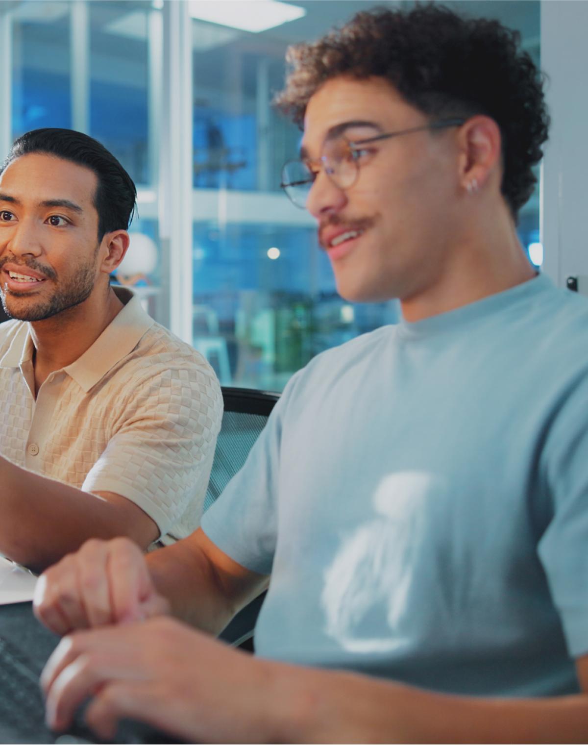 Two colleagues at an AI company collaborating on their computers, supported by Pebl’s EOR for AI solution