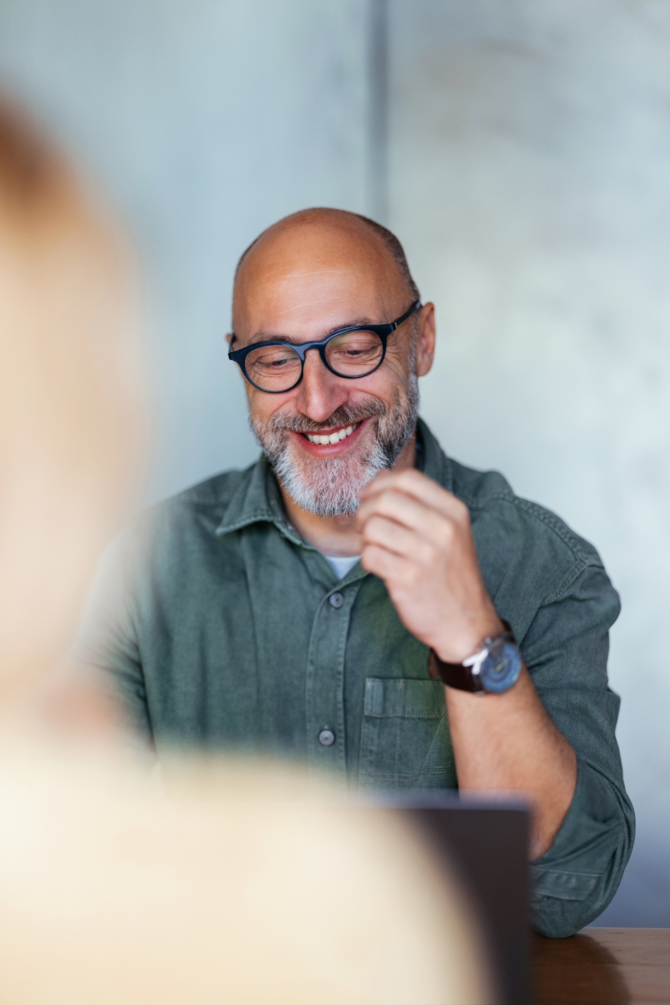 Male employer smiling while looking Pebl M&A services on computer.