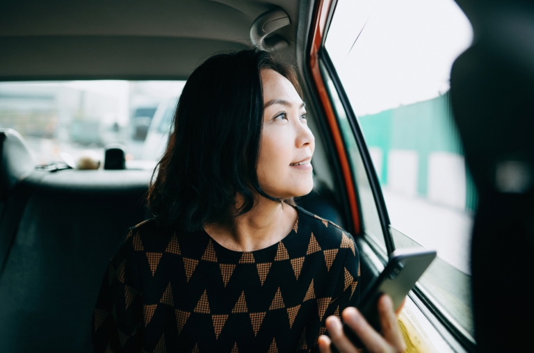 A busy CEO keeps track of her global workforce from the back of a cab because of the Pebl Global Work Platform™