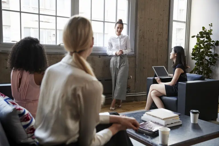 Business-woman-talking-to-team-at-a-meeting.jpg