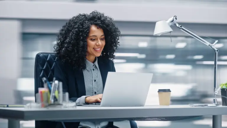 Businesswoman-Sitting-at-Her-Desk-Working-on-a-Laptop.jpg