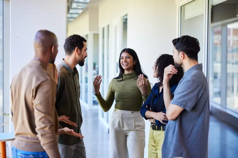business-woman-talking-with-colleagues-in-an-office-hallway.jpg