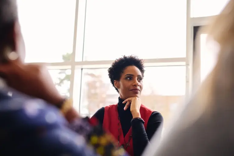 businesswoman-listening-with-hand-on-chin-in-meeting-room.jpg