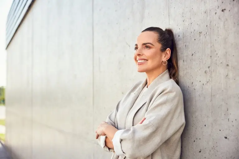 businesswoman-looking-up-standing-against-concrete-wall.jpg