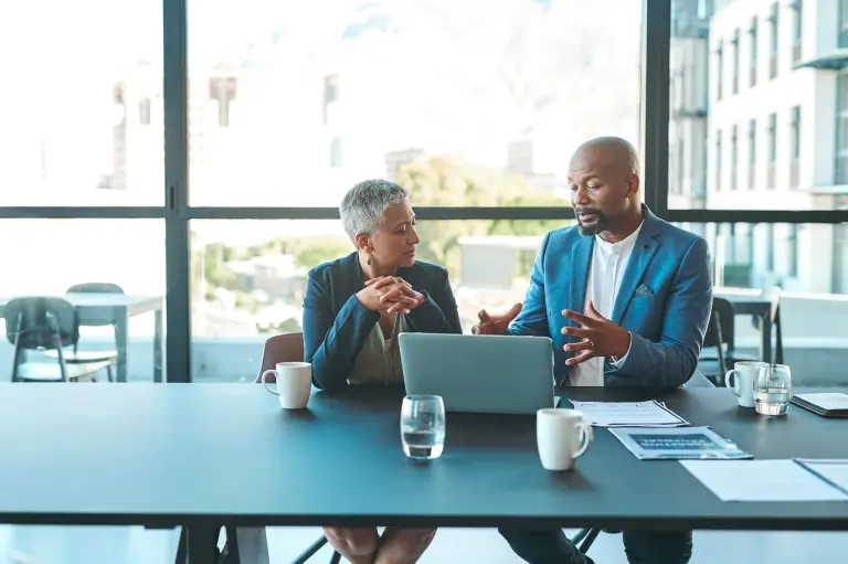 man-and-woman-on-a-laptop-in-a-conference-room.jpg