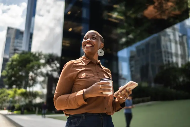woman-holding-smartphone-and-looking-away-outdoors.jpg
