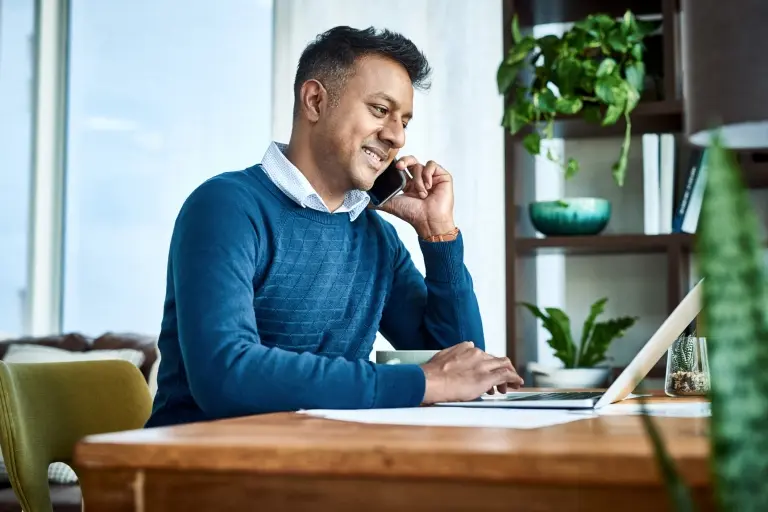 businessman-using-a-laptop-and-smartphone-while-working-from-home.jpg