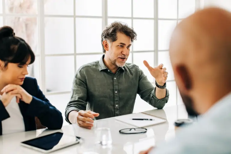man-having-a-discussion-with-his-team-in-an-office.jpg