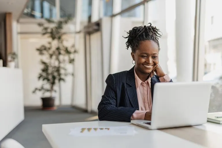 Businesswoman-Smiling-While-Working-at-Her-Laptop.jpg
