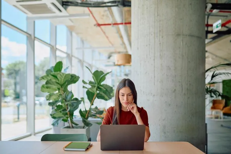 Focused-businesswoman-working-on-laptop-in-modern-office.jpg