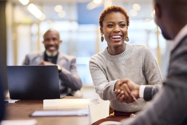 smiling-businesswoman-shakes-hands-with-businessman.jpg