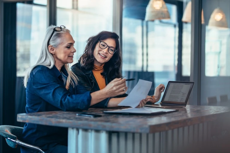 Two-women-analyzing-documents-at-office.jpg