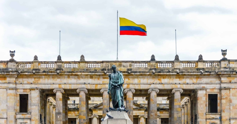 Blog-Images--Venezuelan-Expats-in-Colombia-Work-Permit-Processes-and-Ensuring-Compliant-Hiring Colombian flag over monument