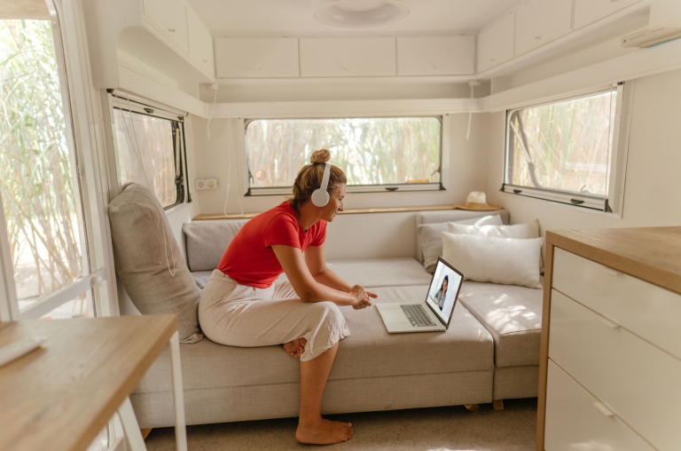How to Have One on One Meetings Woman sitting in her RV van with head phones, taking a video call