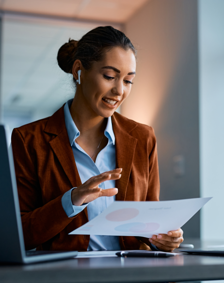 Woman talking through AirPods while looking at a sheet of paper