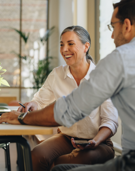woman and man sitting at table looking at computer