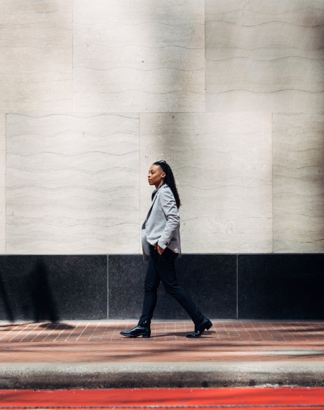 Global employer walking along an urban street during the day.