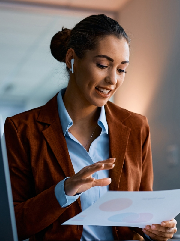 Woman talking on the phone while holding business paper