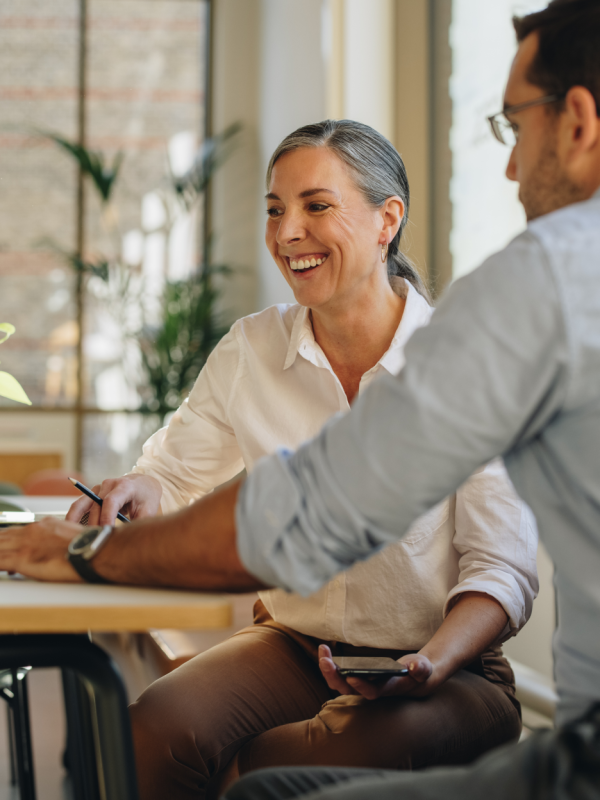 woman and man sitting at table looking at computer