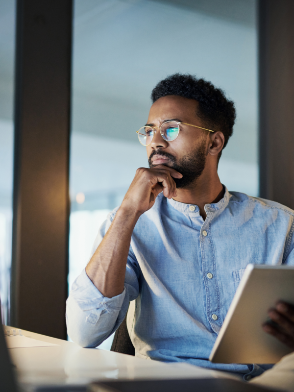 Man holding notebook looking at computer