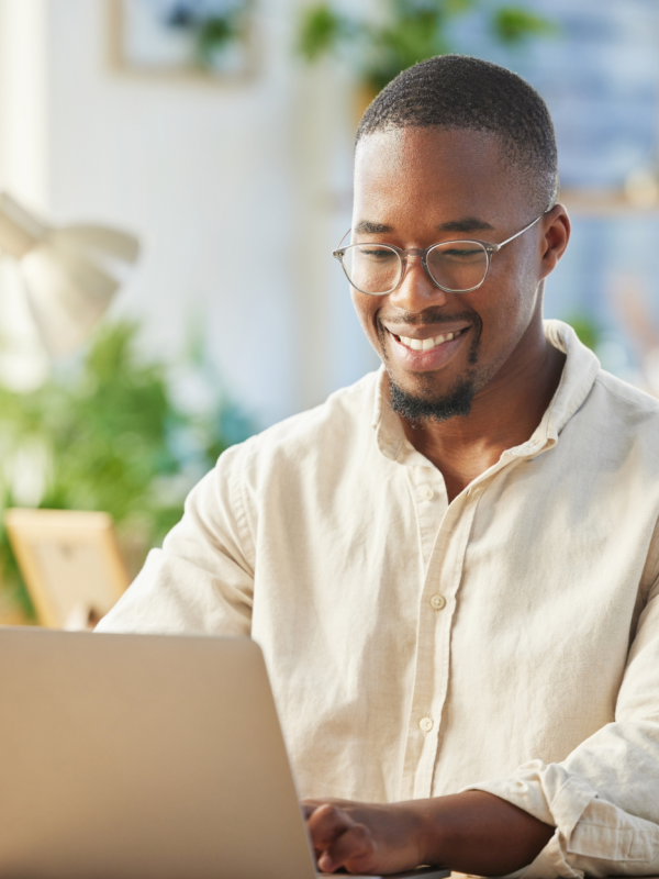 Smiling man using laptop at home