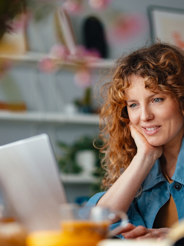 Woman reviewing EOR service provider comparison on laptop.
