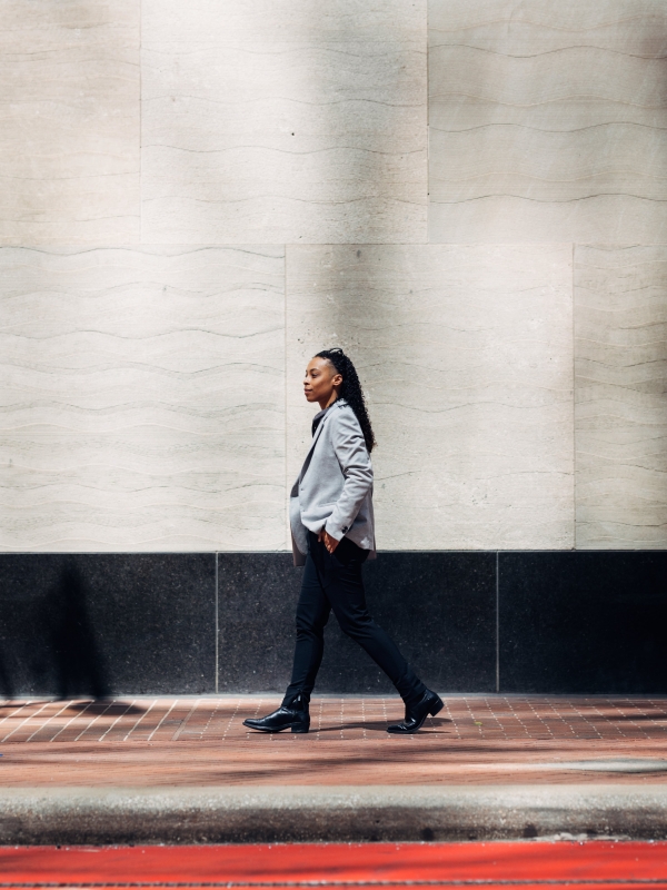 Global employer walking along an urban street during the day.