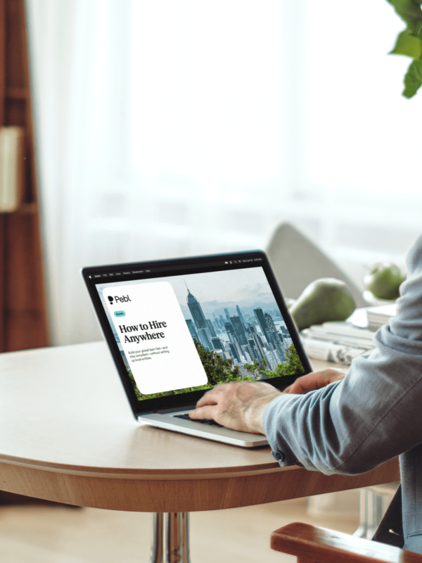 Person looking at How to Hire Anywhere guide on laptop.