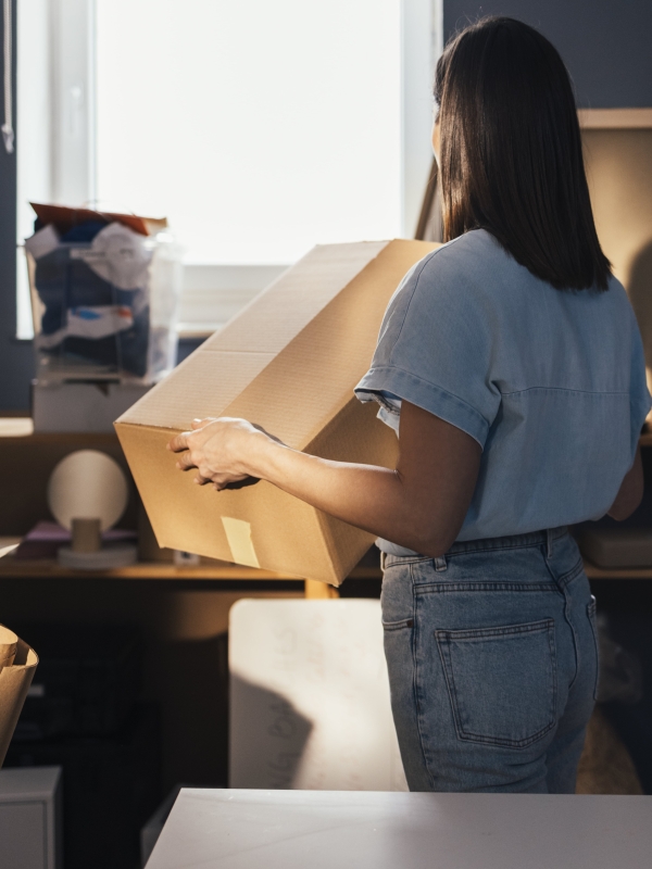 Small business retail owner unpacking boxes after using Pebl EOR for global expansion.