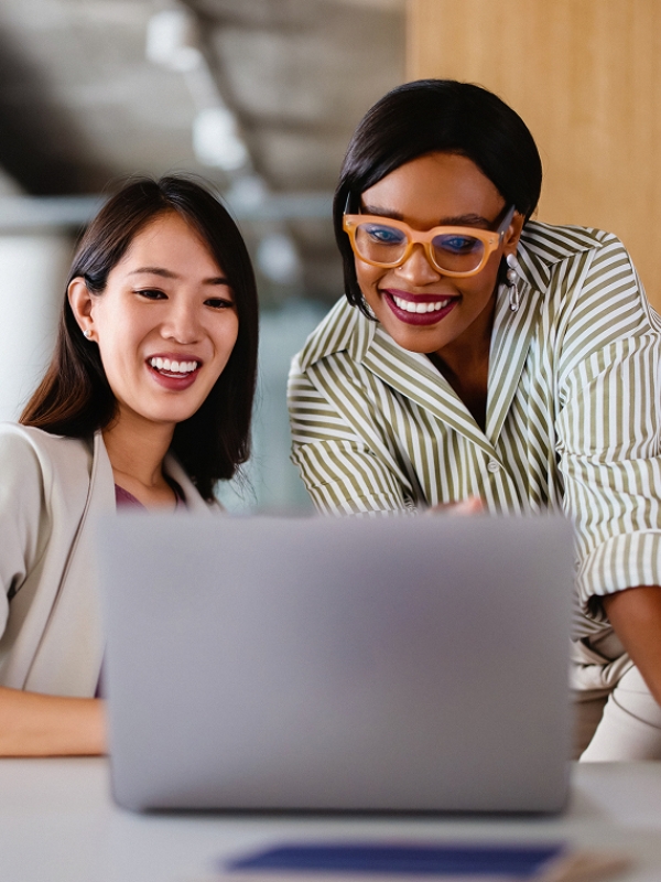 Two team members at an AI company reviewing work on a laptop, highlighting the power of hiring AI skills for innovation