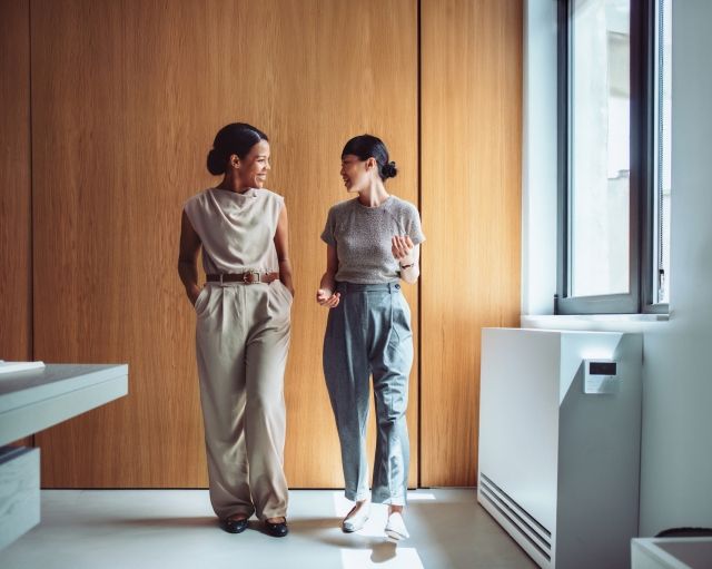 Female colleagues walking down a hallway discussing global M&A.