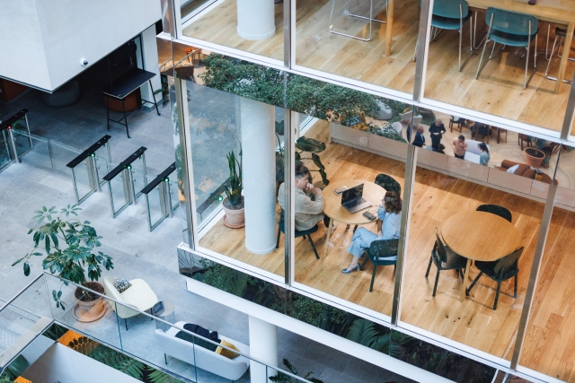 Overhead view of colleagues meeting in a modern office building with glass walls.