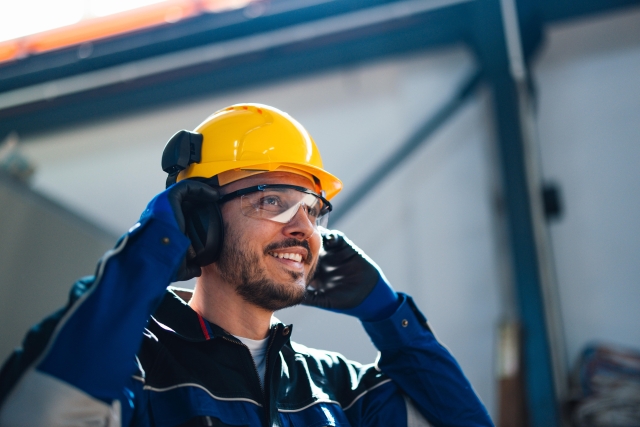 Man in construction zone with hard hat and safety glasses.