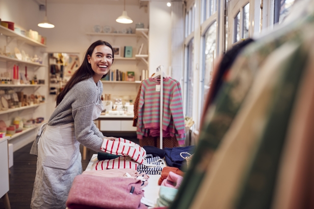 Boutique retail owner restocking store after using Pebl for EOR services.