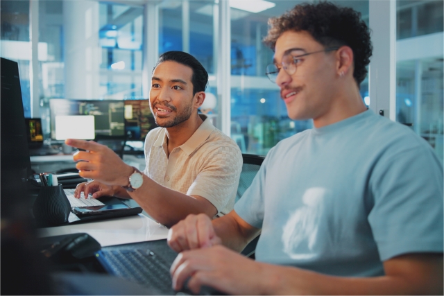 Two colleagues at an AI company collaborating on their computers, supported by Pebl’s EOR for AI solution
