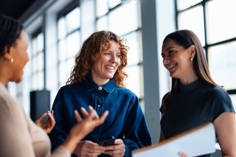 Female colleagues smiling while discussing EOR finance team options with Pebl.