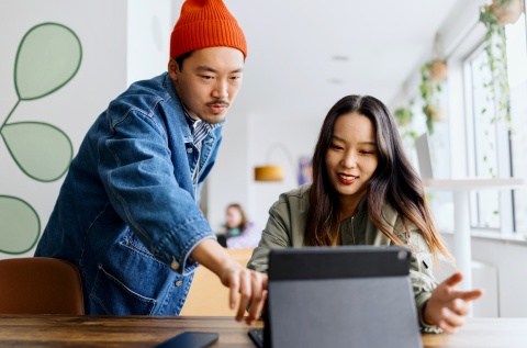 Two remote employees working together from a co-working space in Asia.