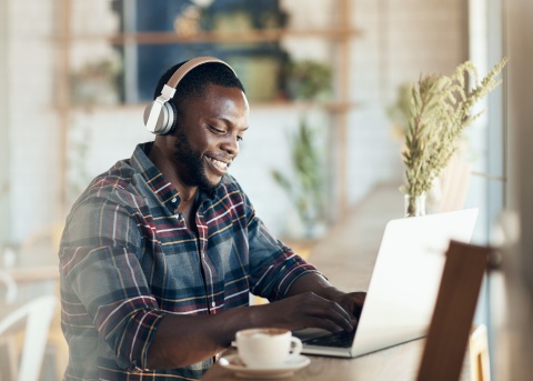 Man smiling while typing on laptop
