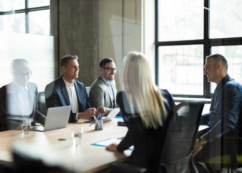 Executives negotiate a merger and acquisition around a conference table.