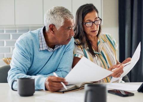 Two professionals reviewing employer payroll tax requirements