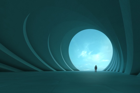 Man standing in a building looking out to the sky.