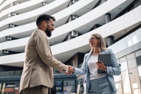 Business people in Dominica shaking hands in front of an office building