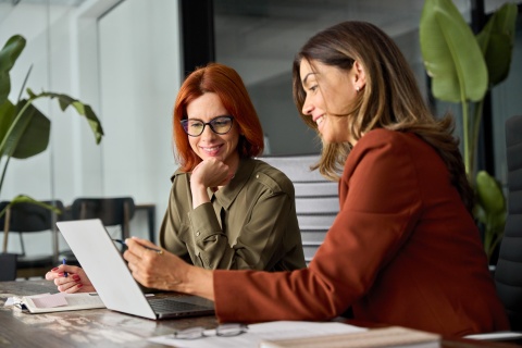 Female coworkers working together at a computer in an office in Barbados