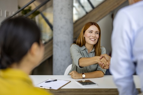 Businesswoman shaking hands with colleague after discussing salary in Mauritania